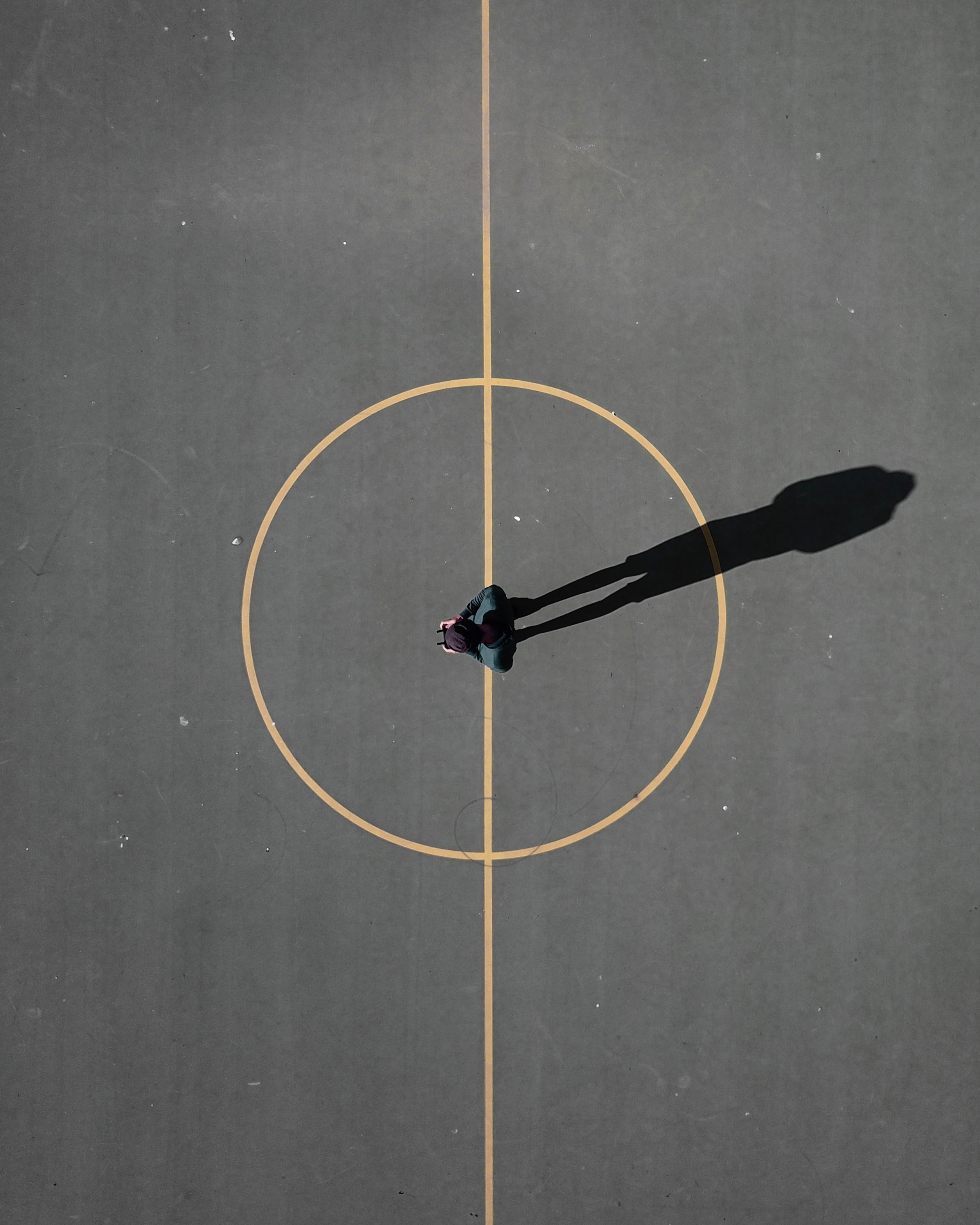 Person at the center of basketball court with drone controller in hand_unsplash_luis-eusebio-2022
